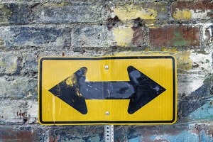 Two-way arrow in front of brick wall