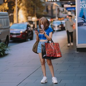 woman holding two smartphones busy texting