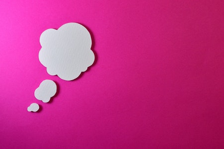 Paper cut-out of cloud on pink paper background